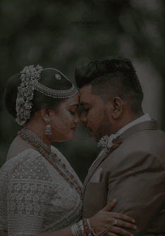 Couple pressing foreheads together in a green garden