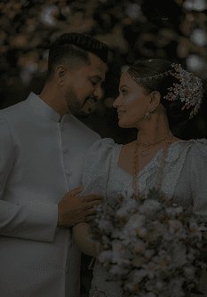 Bride with a bouquet and groom standing in a bright hallway